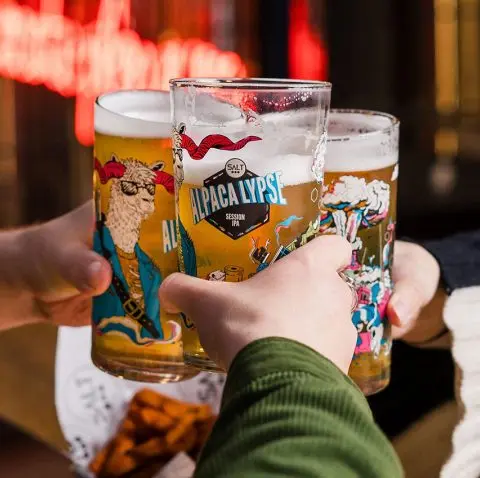 Three pints of Salt Alpacalypse raised in a toast at the bar