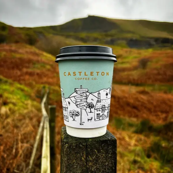 A Castleton Coffee takeaway cup on a fence post in the Peaks