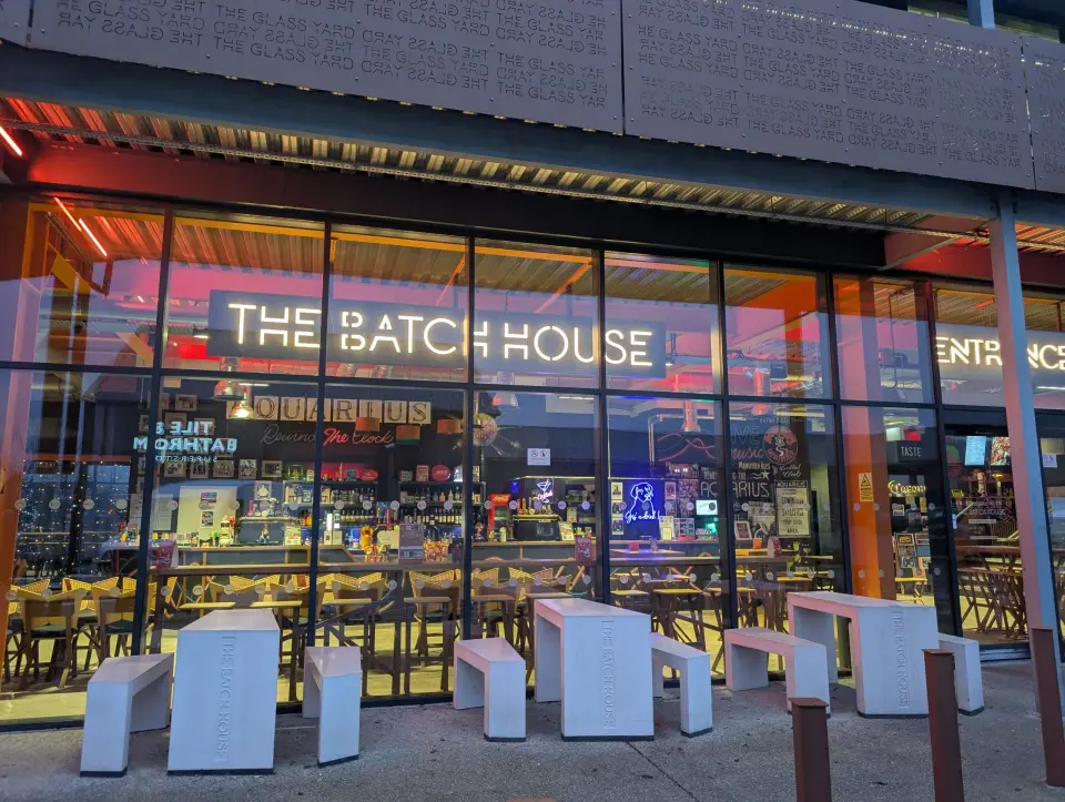 The Batch House at dusk, its neon sign lit above the glass frontage