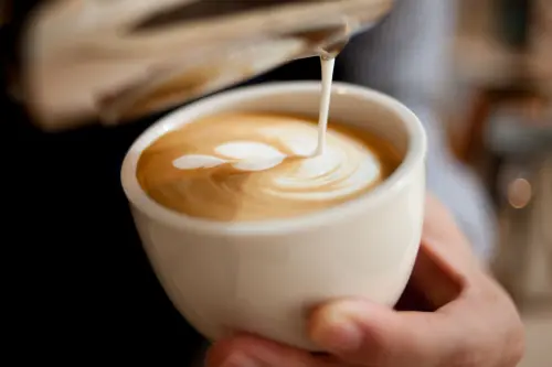 Latte art being poured (stand-in photo)