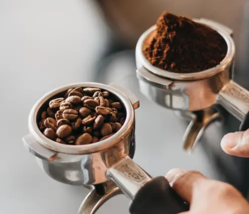 Espresso portafilters, one with beans and one with ground coffee
